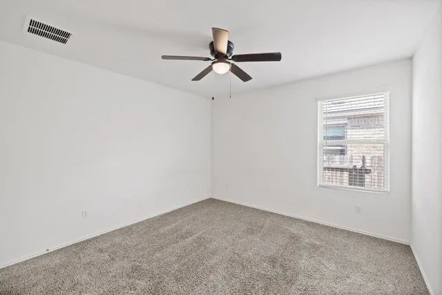 a view of empty room with ceiling fan