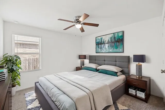 a bedroom with a large bed and a chandelier