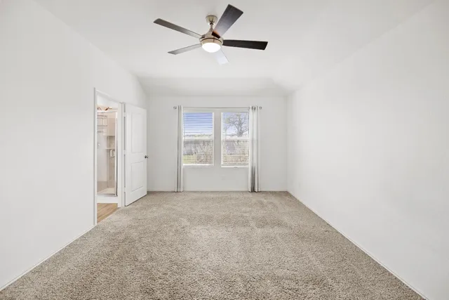 an empty room with fan and windows