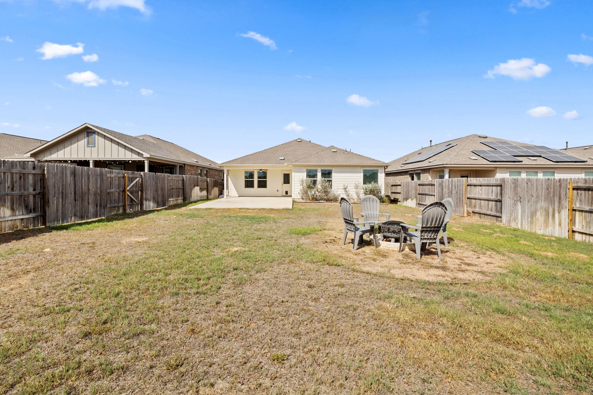 127 George Kimble Cove Bastrop, TX 78602 - Photo 35 of 40 Rear view of property with a patio area, an outdoor fire pit, and a fenced backyard