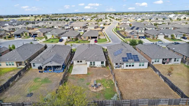 an aerial view of residential houses with outdoor space and swimming pool