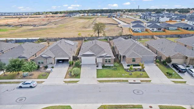 an aerial view of residential houses with outdoor space and ocean view
