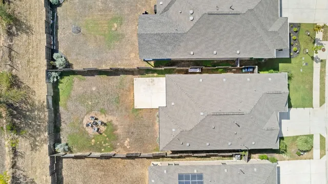 an aerial view of a residential houses with yard
