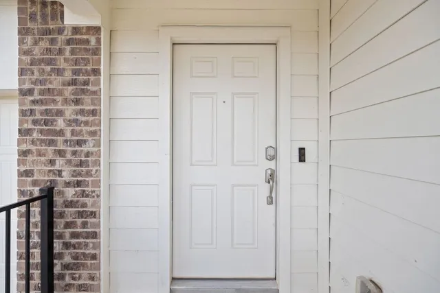 a view of a hallway with wooden floor and a ceiling fan