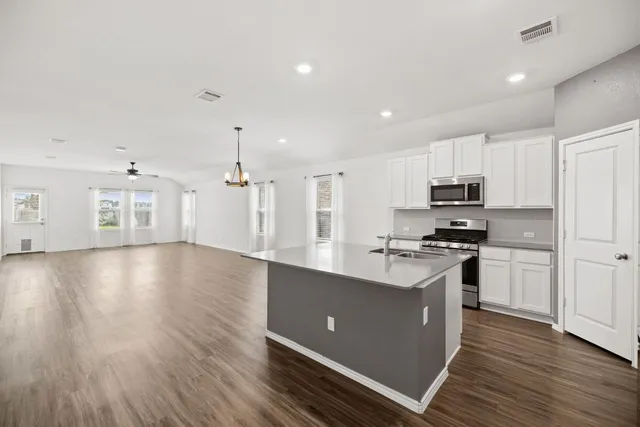 a large kitchen with stainless steel appliances a refrigerator and a stove top oven