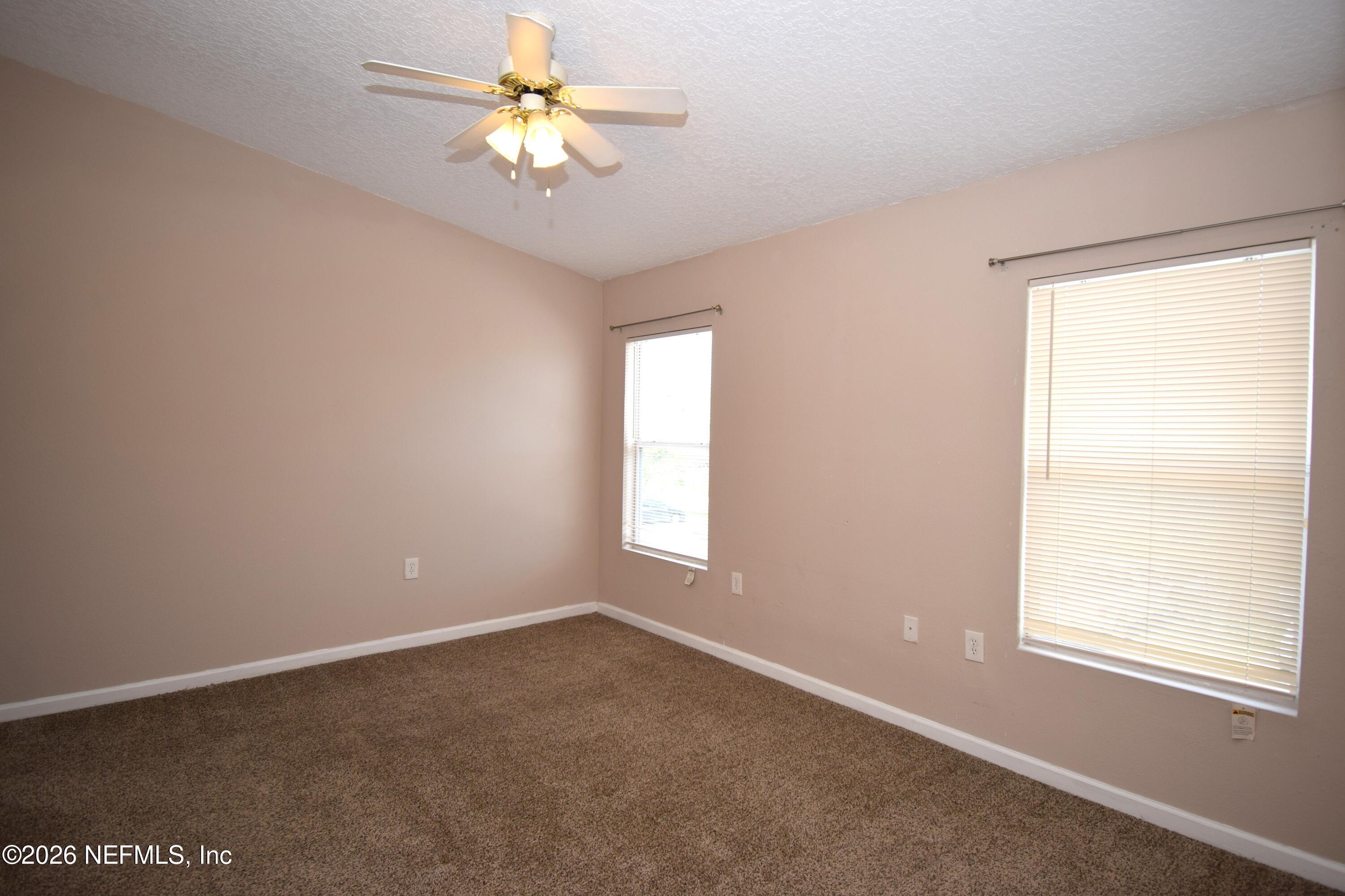 7920 Merrill Road, Unit 1811 Jacksonville, FL 32277 - Photo 11 of 15 an empty room with windows and fan