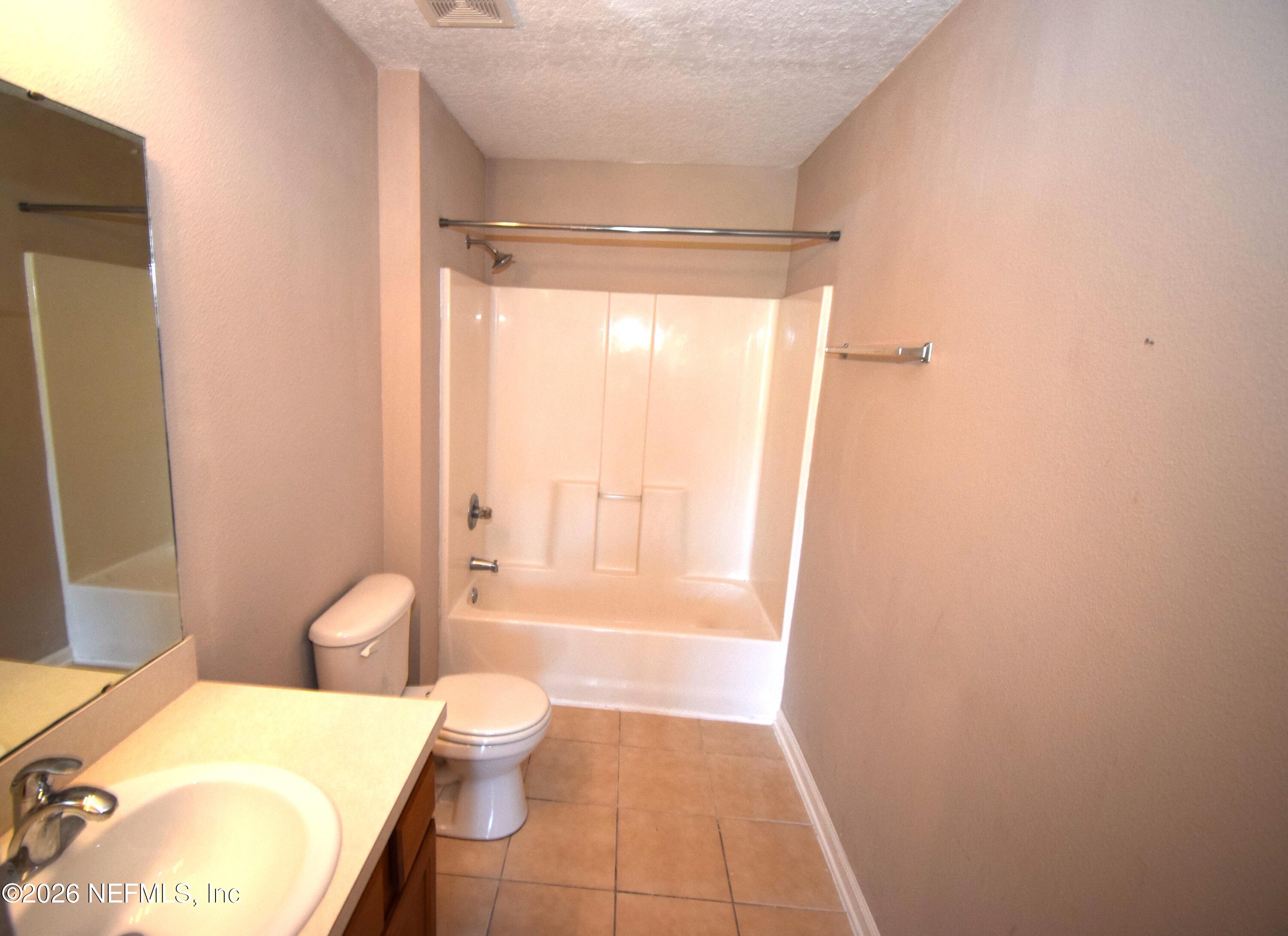 7920 Merrill Road, Unit 1811 Jacksonville, FL 32277 - Photo 12 of 15 a bathroom with a granite countertop sink toilet and shower