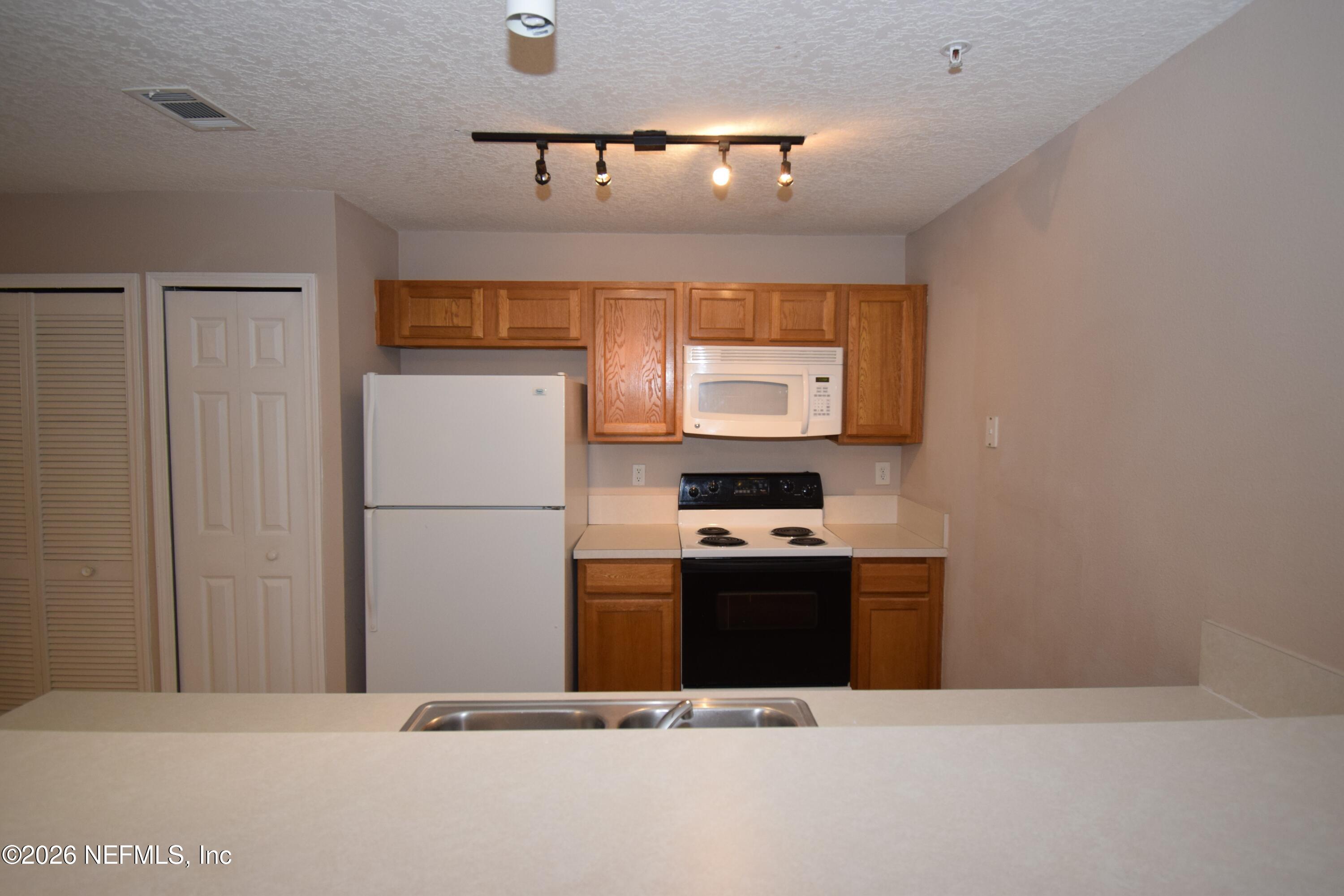 7920 Merrill Road, Unit 1811 Jacksonville, FL 32277 - Photo 6 of 15 a kitchen with stainless steel appliances a refrigerator and a stove