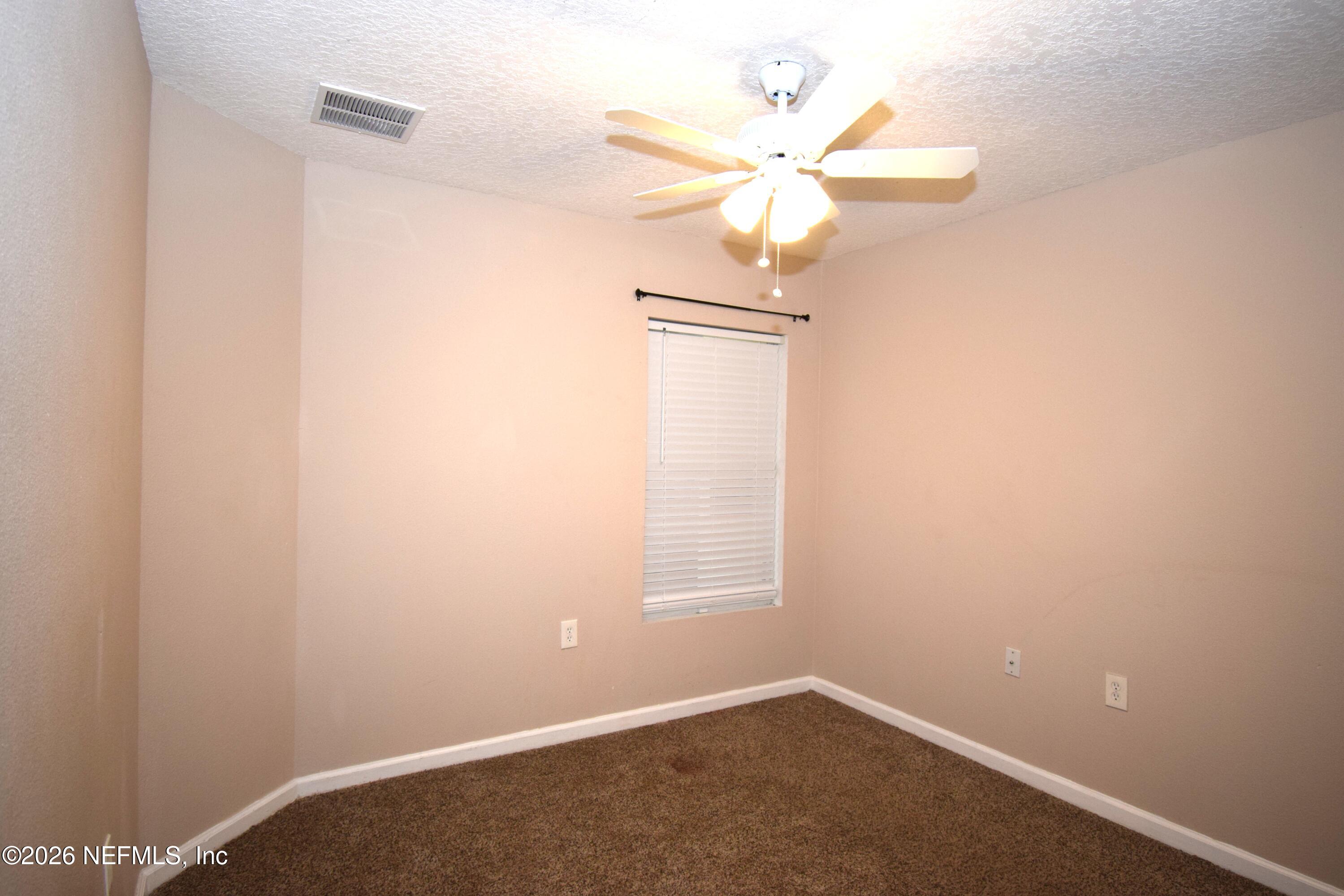 7920 Merrill Road, Unit 1811 Jacksonville, FL 32277 - Photo 9 of 15 an empty room with a window and a fan