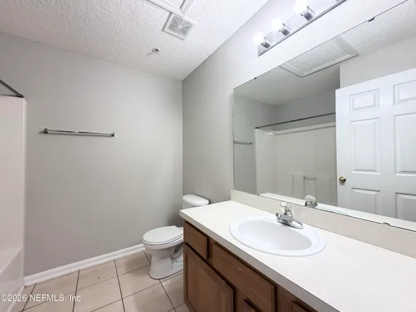 a bathroom with a sink a toilet and mirror