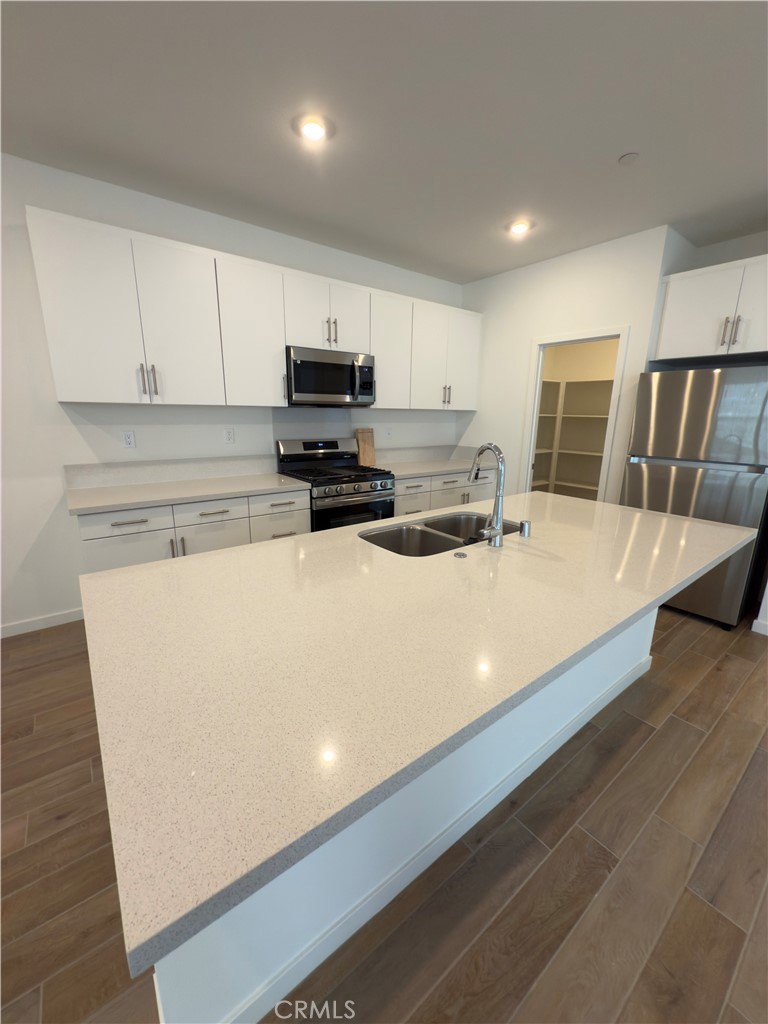 15844 Caterpillar Drive Fontana, CA 92336 - Photo 5 of 19 a kitchen with stainless steel appliances a refrigerator sink and microwave