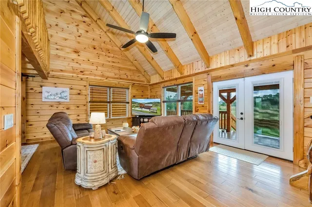 a living room with furniture a wooden floor and next to a window