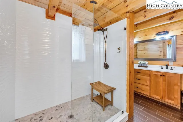 a bathroom with a shower a sink and a mirror