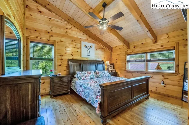 a bedroom with a bed and large windows