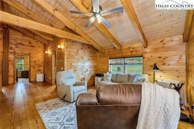 a living room with couches a fireplace with wooden floor