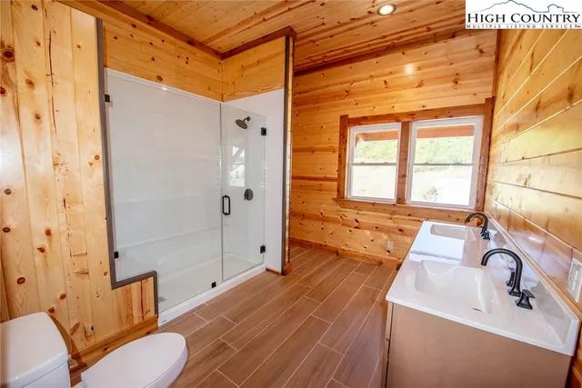 a bathroom with a tub shower sink and mirror