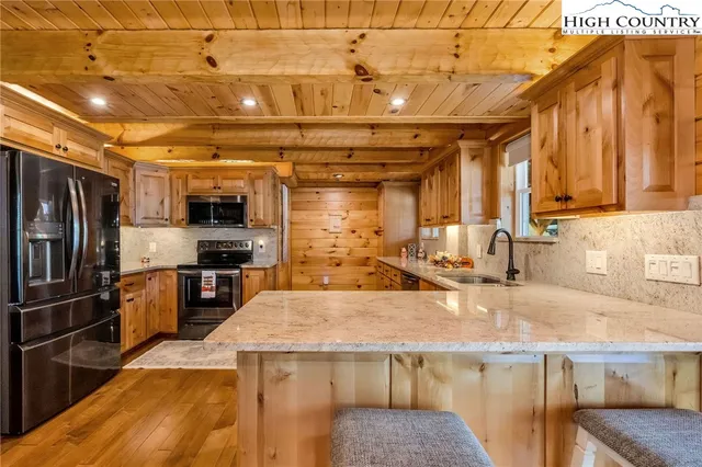 a kitchen with kitchen island granite countertop a sink and stainless steel appliances