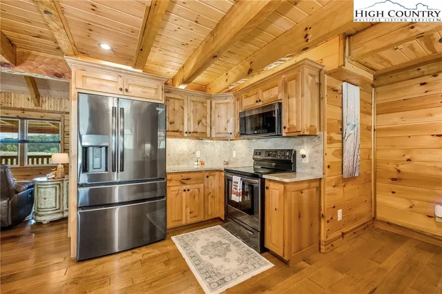 a kitchen with stainless steel appliances granite countertop a refrigerator a stove top oven a sink and dishwasher