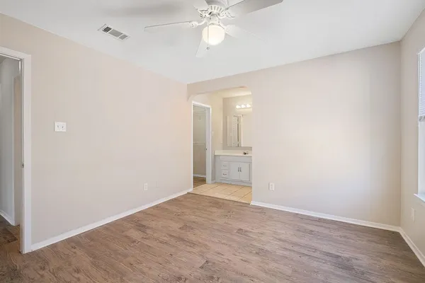 a view of a room with a ceiling fan and hardwood floor