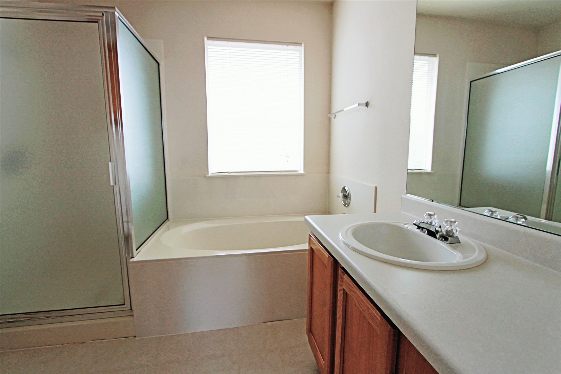 1821 Friars Tale Lane Austin, TX 78748 - Photo 13 of 20 Bathroom with vanity, a stall shower, and a garden tub