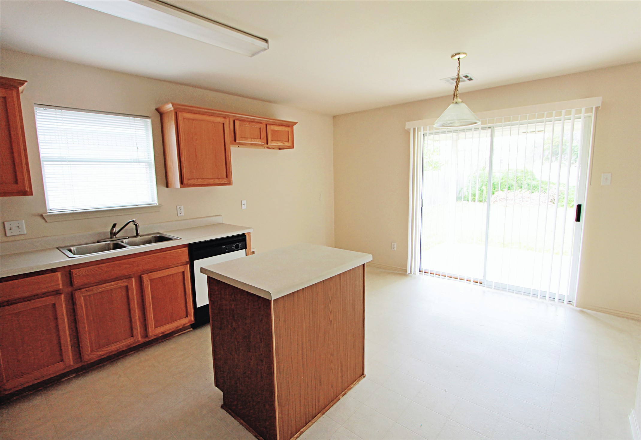 1821 Friars Tale Lane Austin, TX 78748 - Photo 6 of 20 Kitchen featuring light floors, light countertops, a kitchen island, dishwasher, and healthy amount of natural light