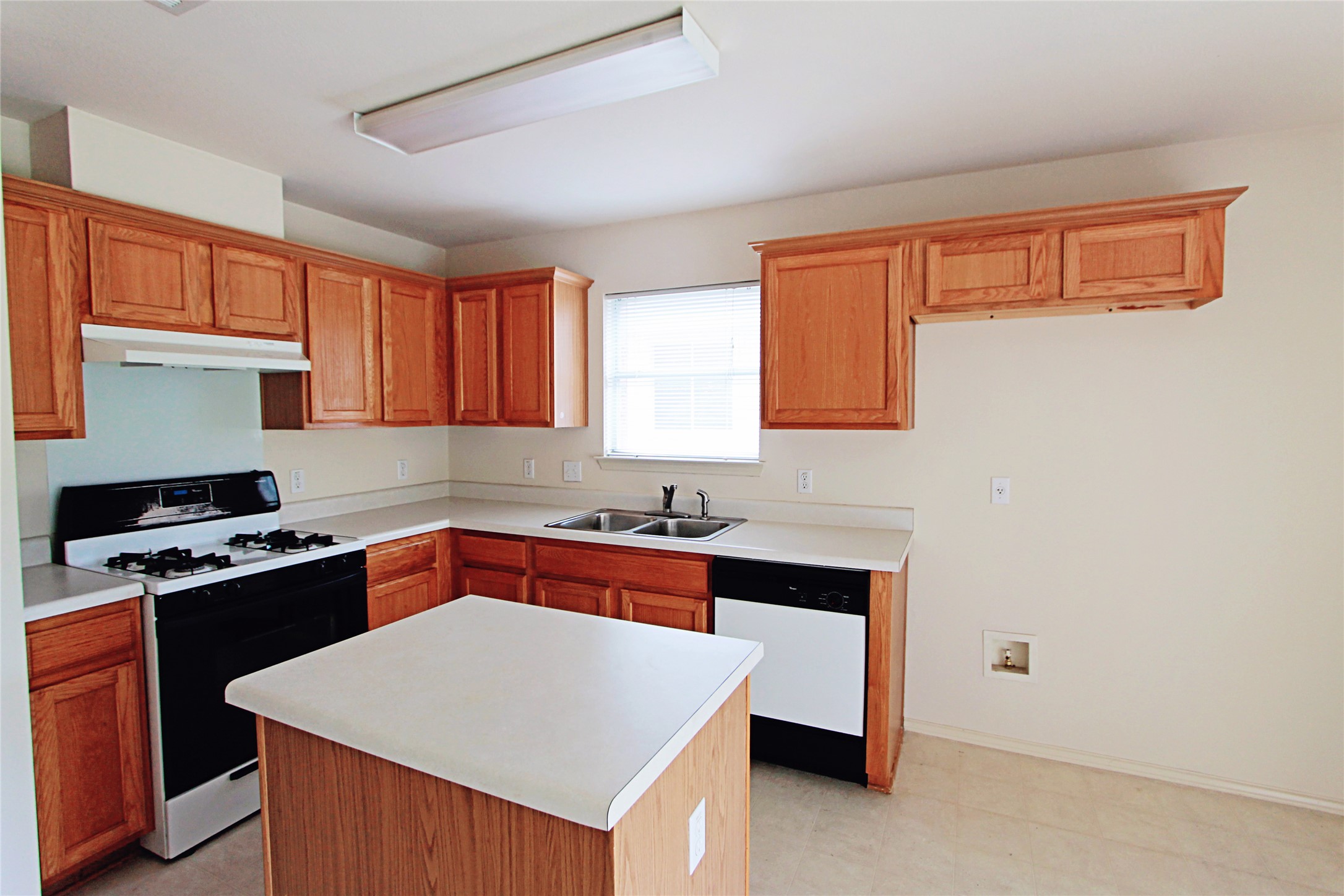 1821 Friars Tale Lane Austin, TX 78748 - Photo 7 of 20 Kitchen featuring range with gas stovetop, light floors, light countertops, dishwasher, and a kitchen island