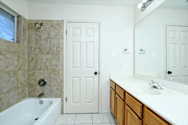 a bathroom with a double vanity sink a mirror and a bathtub