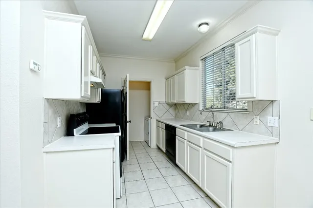 a kitchen that has a sink a stove and a refrigerator