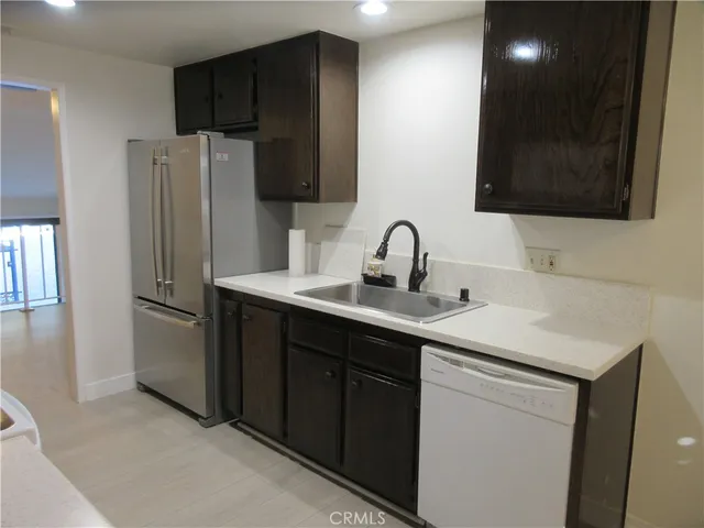 a kitchen with stainless steel appliances a sink stove and refrigerator