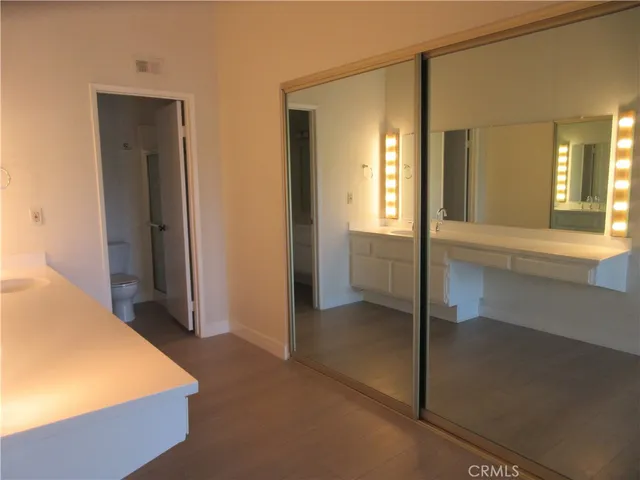 a bathroom with a sink and mirror with toilet