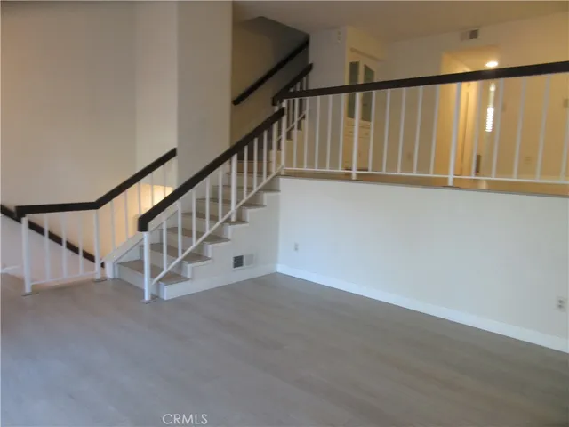 a view of staircase with wooden floor and white walls