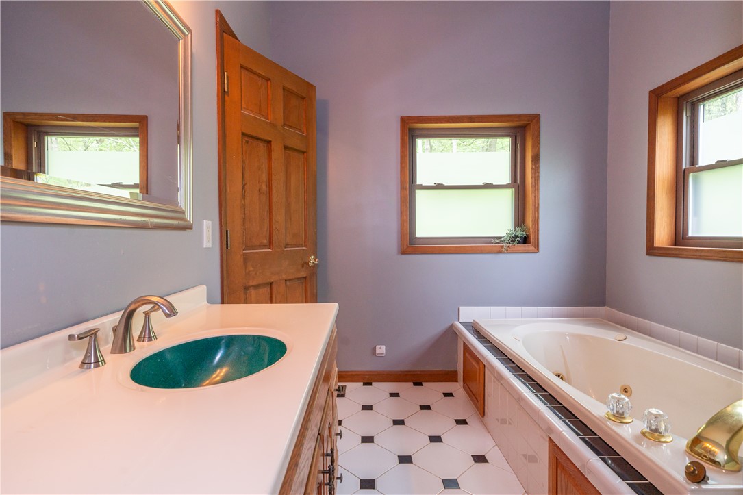 10584 New Biddinger Road Harrison, OH 45030 - Photo 31 of 61 This bathroom features a deep soaking tub and a vanity with a unique basin.