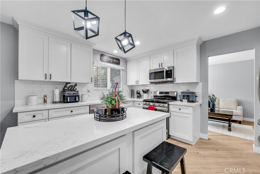 5991 Rogers Lane San Bernardino, CA 92404 - Photo 11 of 33 a kitchen with cabinets a window and stainless steel appliances
