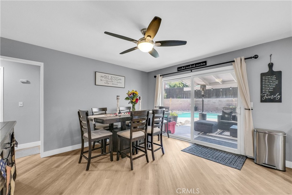 5991 Rogers Lane San Bernardino, CA 92404 - Photo 12 of 33 a dining room with wooden floor a chandelier fan a wooden table and chairs