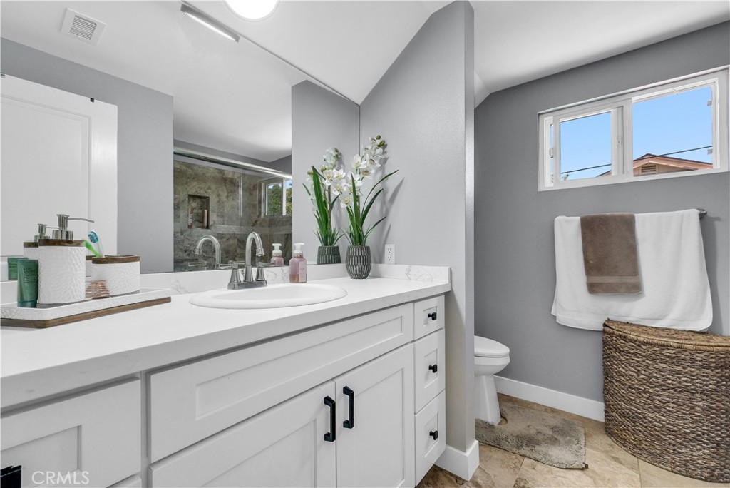 5991 Rogers Lane San Bernardino, CA 92404 - Photo 17 of 33 a bathroom with a sink a toilet and mirror
