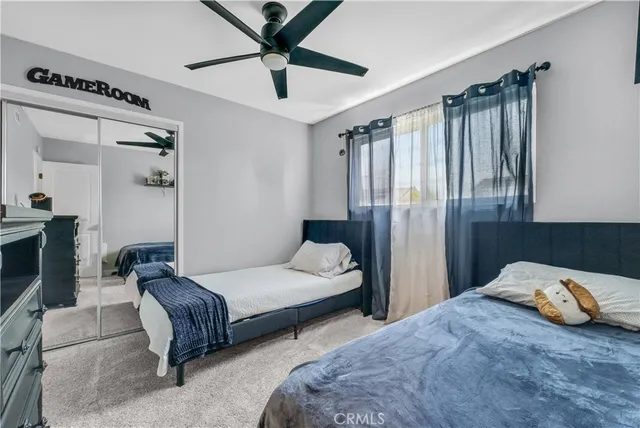 a bedroom with two beds and ceiling fan