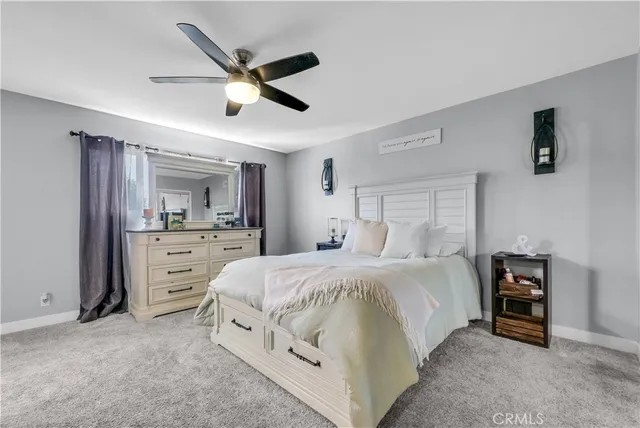 a spacious bedroom with a bed and ceiling fan