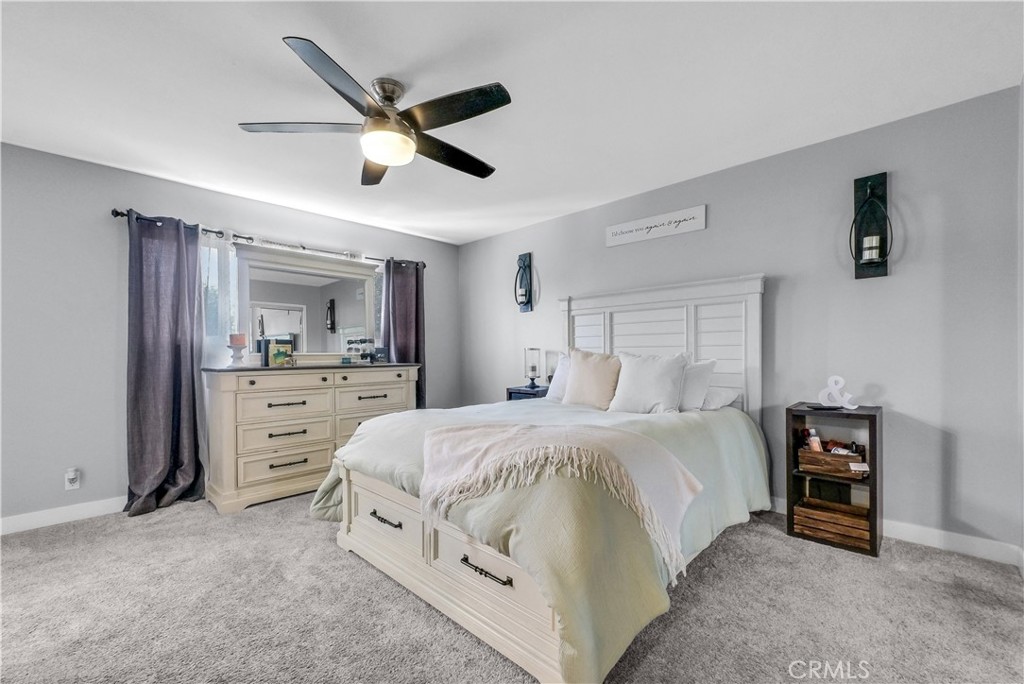 5991 Rogers Lane San Bernardino, CA 92404 - Photo 22 of 33 a spacious bedroom with a bed and ceiling fan