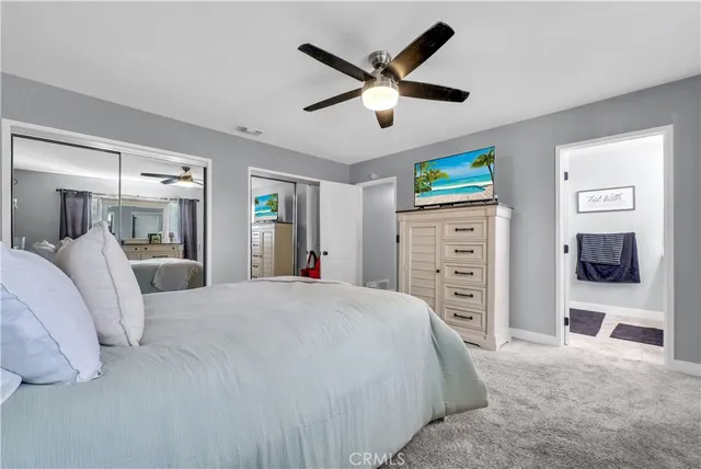 a bedroom with a bed a dresser and a large mirror