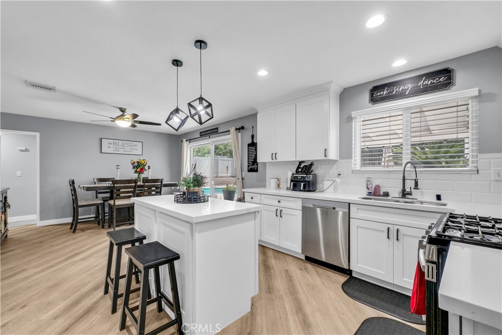 5991 Rogers Lane San Bernardino, CA 92404 - Photo 10 of 33 a kitchen with a stove a sink a dining table and chairs