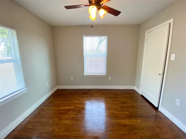 an empty room with window and wooden floor
