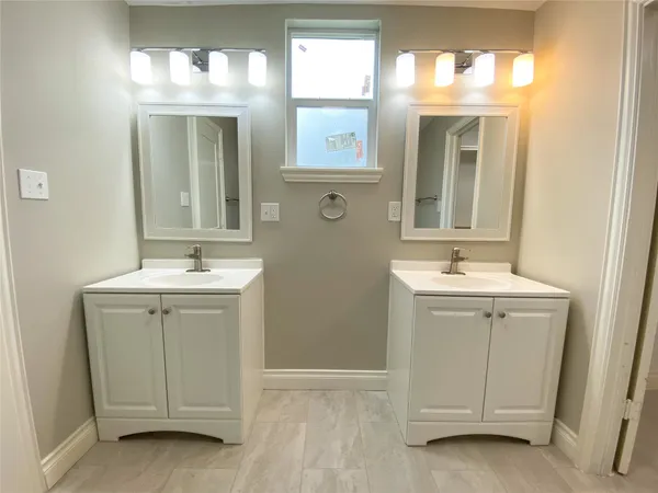 a bathroom with a sink a mirror a vanity and a window