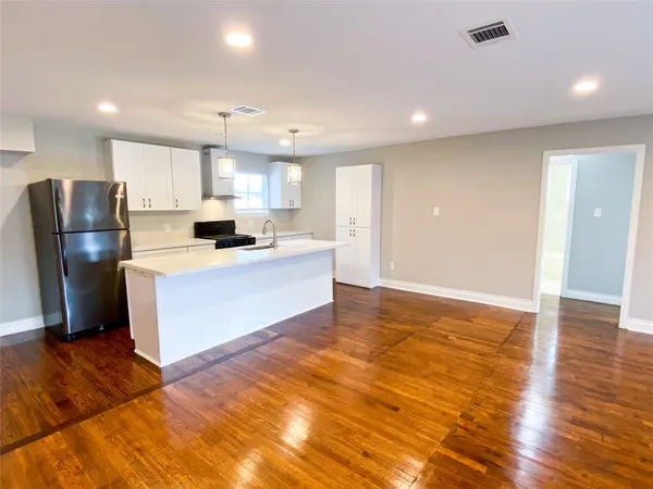 a large kitchen with stainless steel appliances granite countertop a stove a sink and a refrigerator