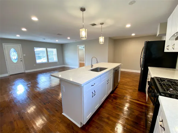 a kitchen with stainless steel appliances granite countertop a sink a oven and a large window