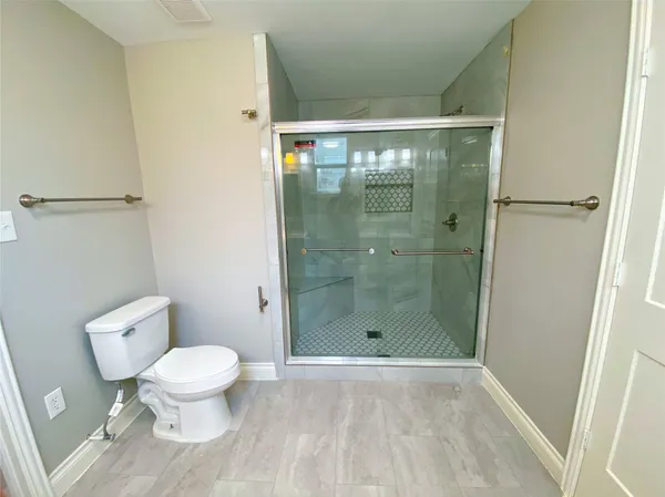 a bathroom with a toilet and a shower