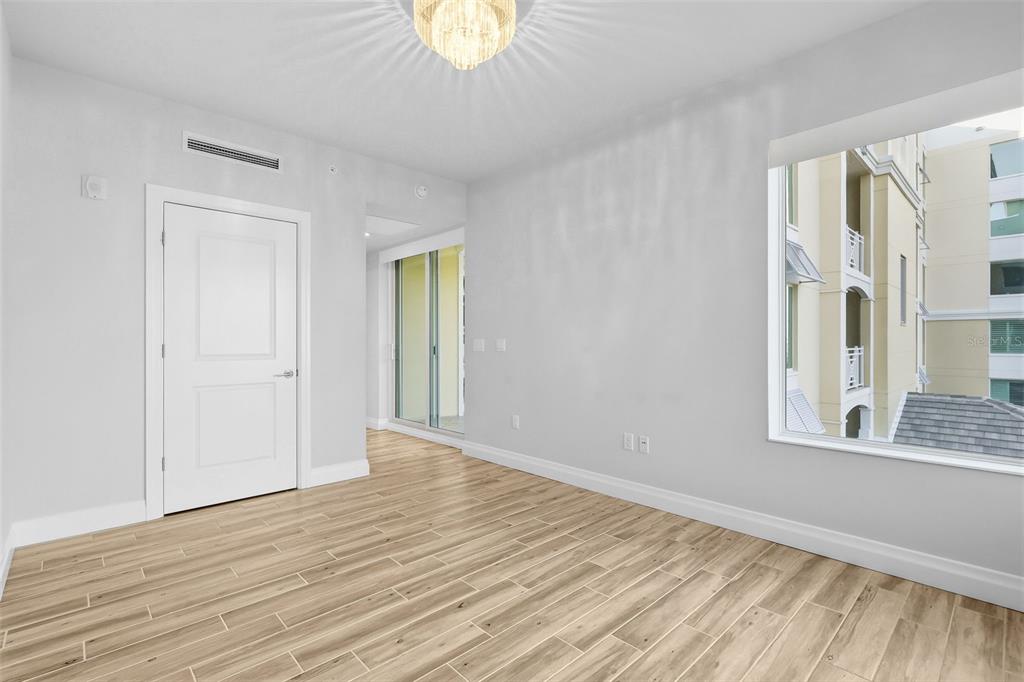 800 Collany Road, Unit 302 St. Petersburg, FL 33715 - Photo 43 of 66 a view of an empty room with wooden floor and a window