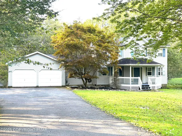 a front view of a house with a yard and trees