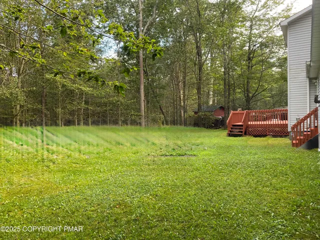 a view of a patio with table and chairs with wooden floor and fence