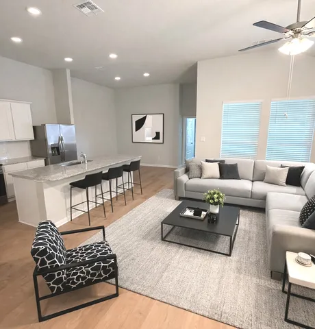 a living room with furniture and a wooden floor