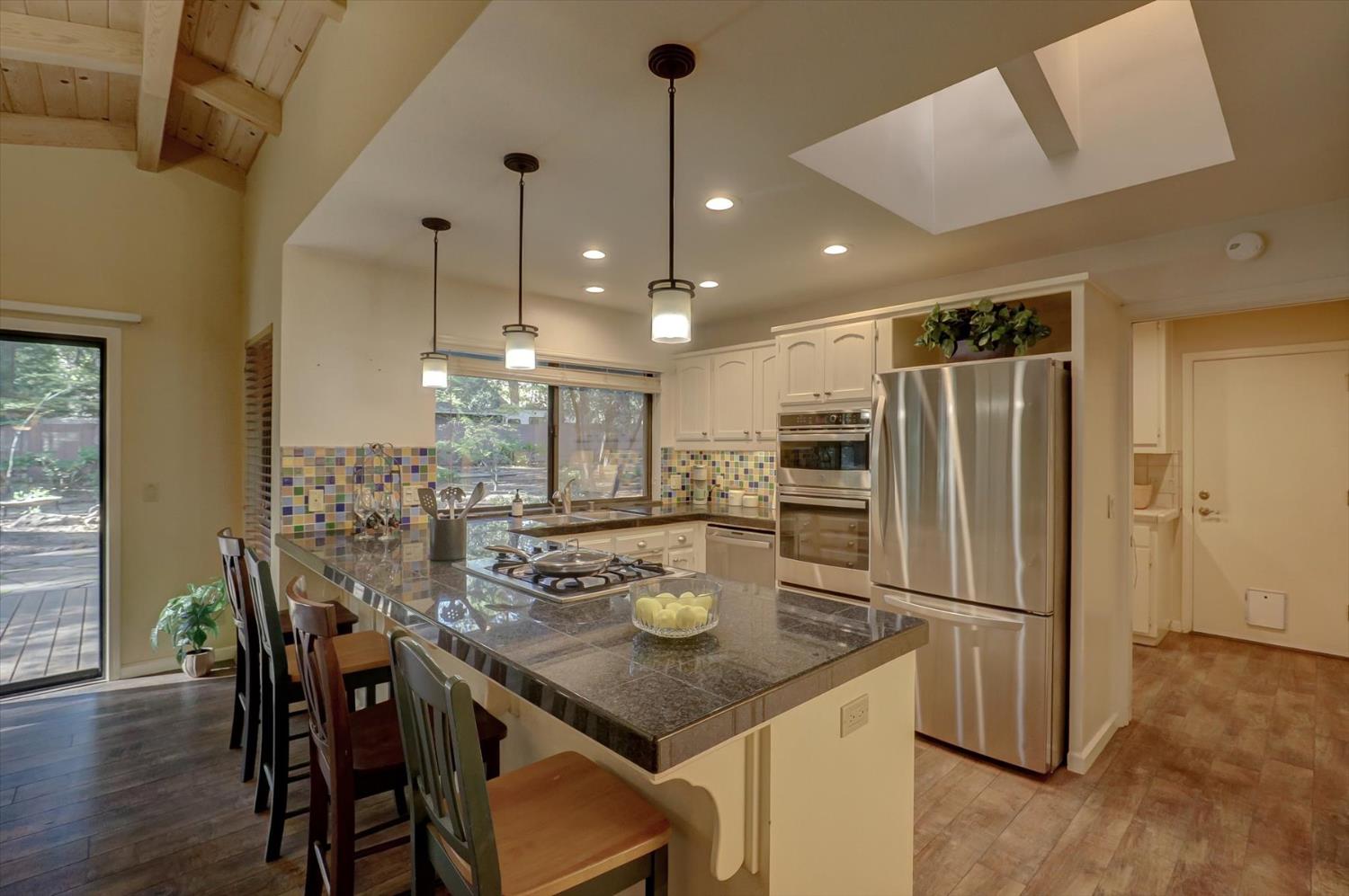 12523 Banner Lava Cap Road Nevada City, CA 95959 - Photo 12 of 57 a kitchen with refrigerator and chairs